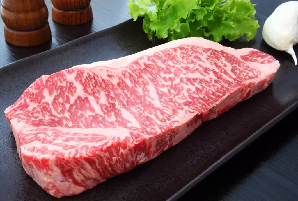 Carne de Wagyu com alto grau de marmoreio, característica marcante das raças de bovinos de corte premium que produzem carne premium.